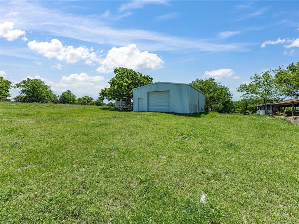 5444 Well Service Road Bowie, TX 76230 - Photo 28 of 38 a view of a big yard with plants and a large tree