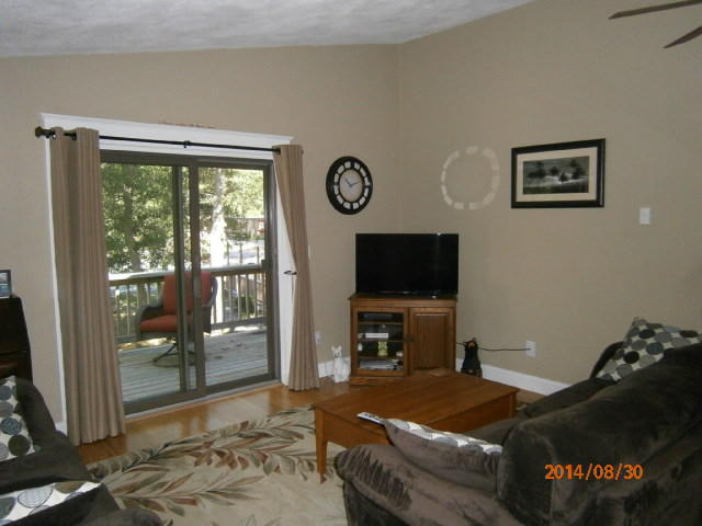 35 Ashumet Road, Unit 8D Mashpee, MA 02649 - Photo 4 of 16 a living room with furniture a flat screen tv and a floor to ceiling window