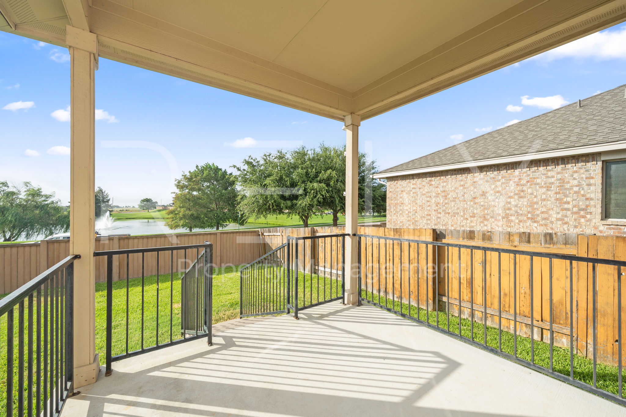 1405 Sunny Meadows Loop Georgetown, TX 78626 - Photo 35 of 40 A tranquil covered patio offers views of the lake with a fountain, perfect for serene outdoor moments.