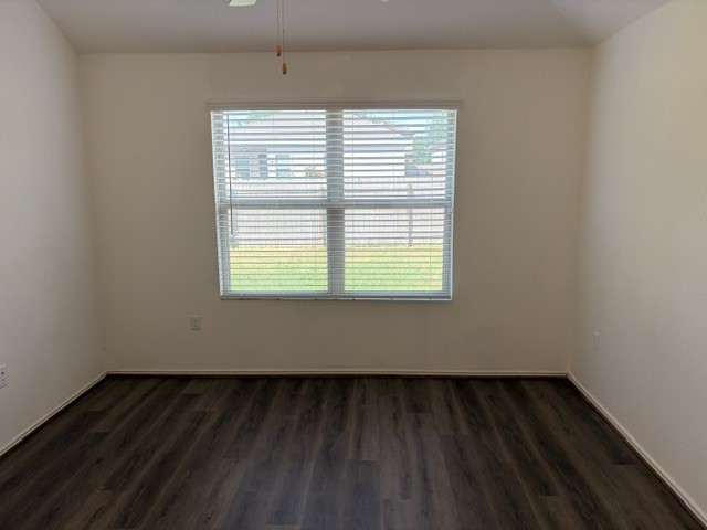 6917 Colorado Bluffs Road Austin, TX 78744 - Photo 6 of 19 a view of an empty room with wooden floor and a window