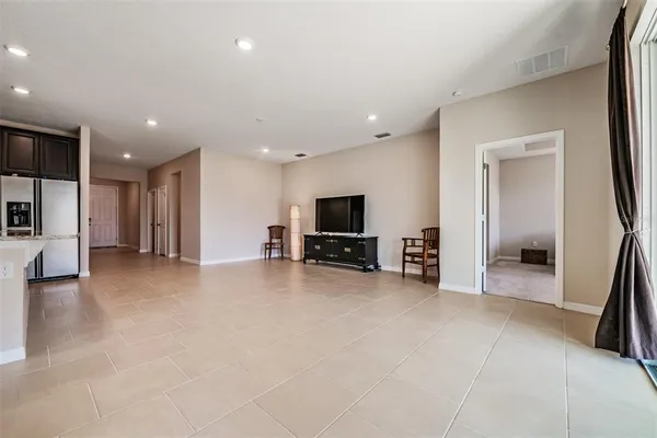 a large kitchen with stainless steel appliances kitchen island granite countertop a refrigerator and a stove top oven