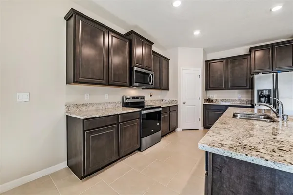 a bathroom with a granite countertop sink a toilet a mirror and bathtub