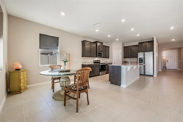 a kitchen with a sink a refrigerator and chairs
