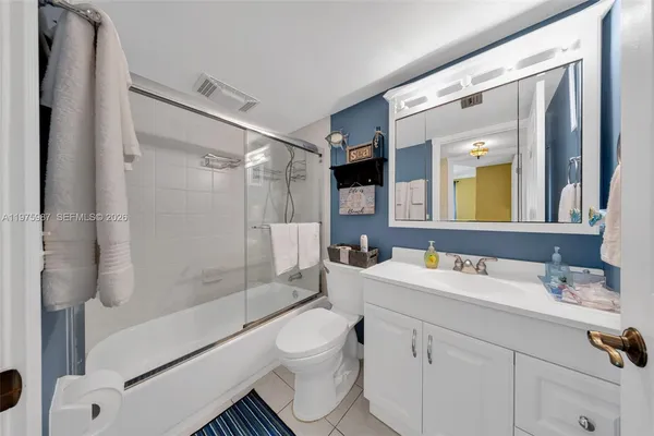 a bathroom with a double vanity sink toilet mirror and shower