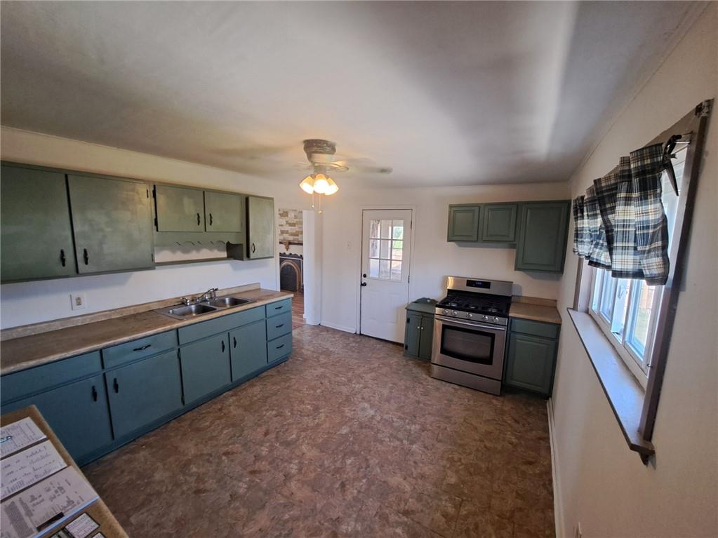 414 Liberty Street Perryopolis, PA 15473 - Photo 13 of 26 a kitchen with stainless steel appliances granite countertop a stove a sink and a refrigerator