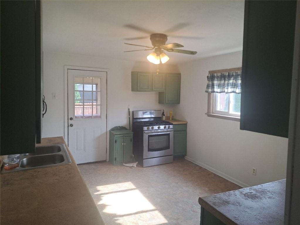 414 Liberty Street Perryopolis, PA 15473 - Photo 14 of 26 a kitchen with stainless steel appliances kitchen island granite countertop a refrigerator a sink a stove and a window