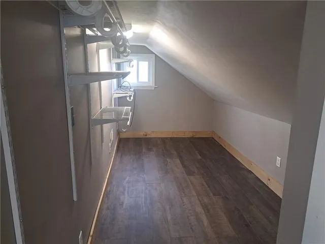 a view of a hallway to room with wooden floor