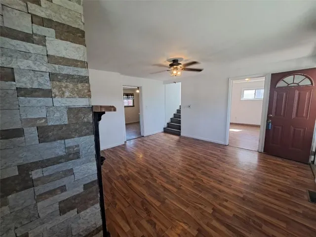 a view of empty room with wooden floor and fireplace