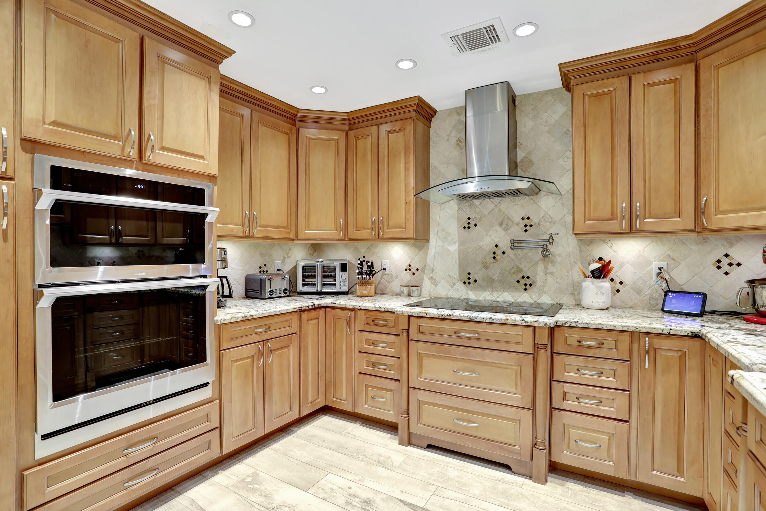 9142 Southwest 22nd Street, Unit E Boca Raton, FL 33428 - Photo 11 of 51 a kitchen with stainless steel appliances granite countertop a stove a sink and a microwave