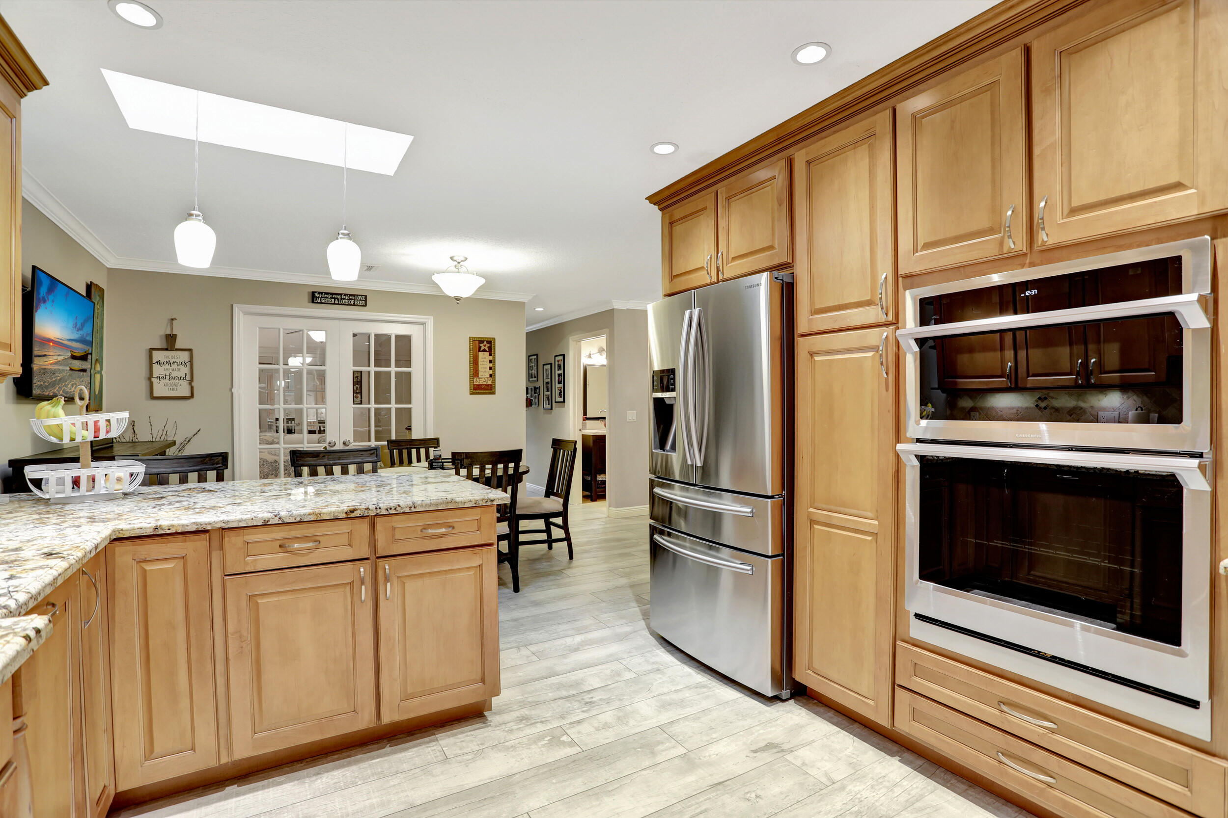 9142 Southwest 22nd Street, Unit E Boca Raton, FL 33428 - Photo 12 of 51 a kitchen with stainless steel appliances kitchen island granite countertop a refrigerator stove and sink