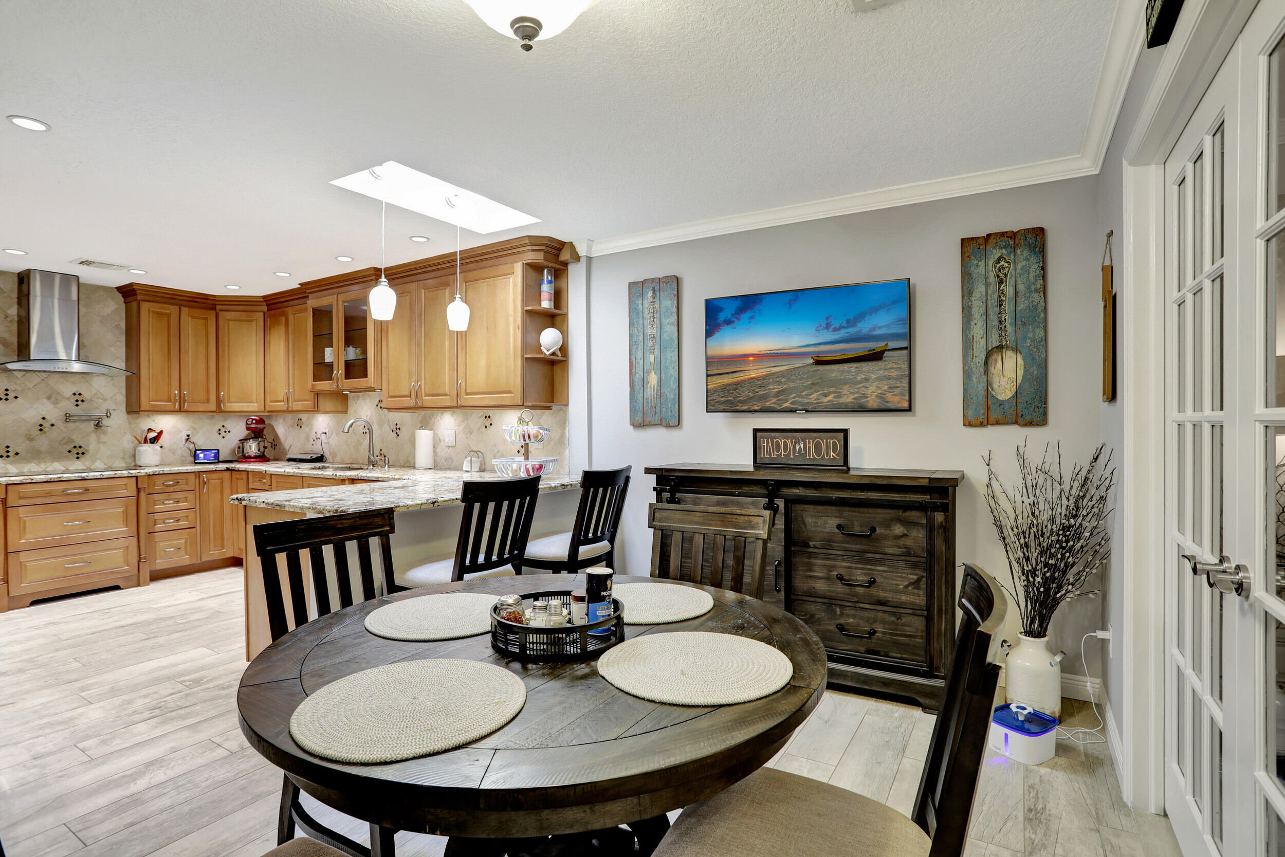 9142 Southwest 22nd Street, Unit E Boca Raton, FL 33428 - Photo 15 of 51 a kitchen with stainless steel appliances a dining table and chairs