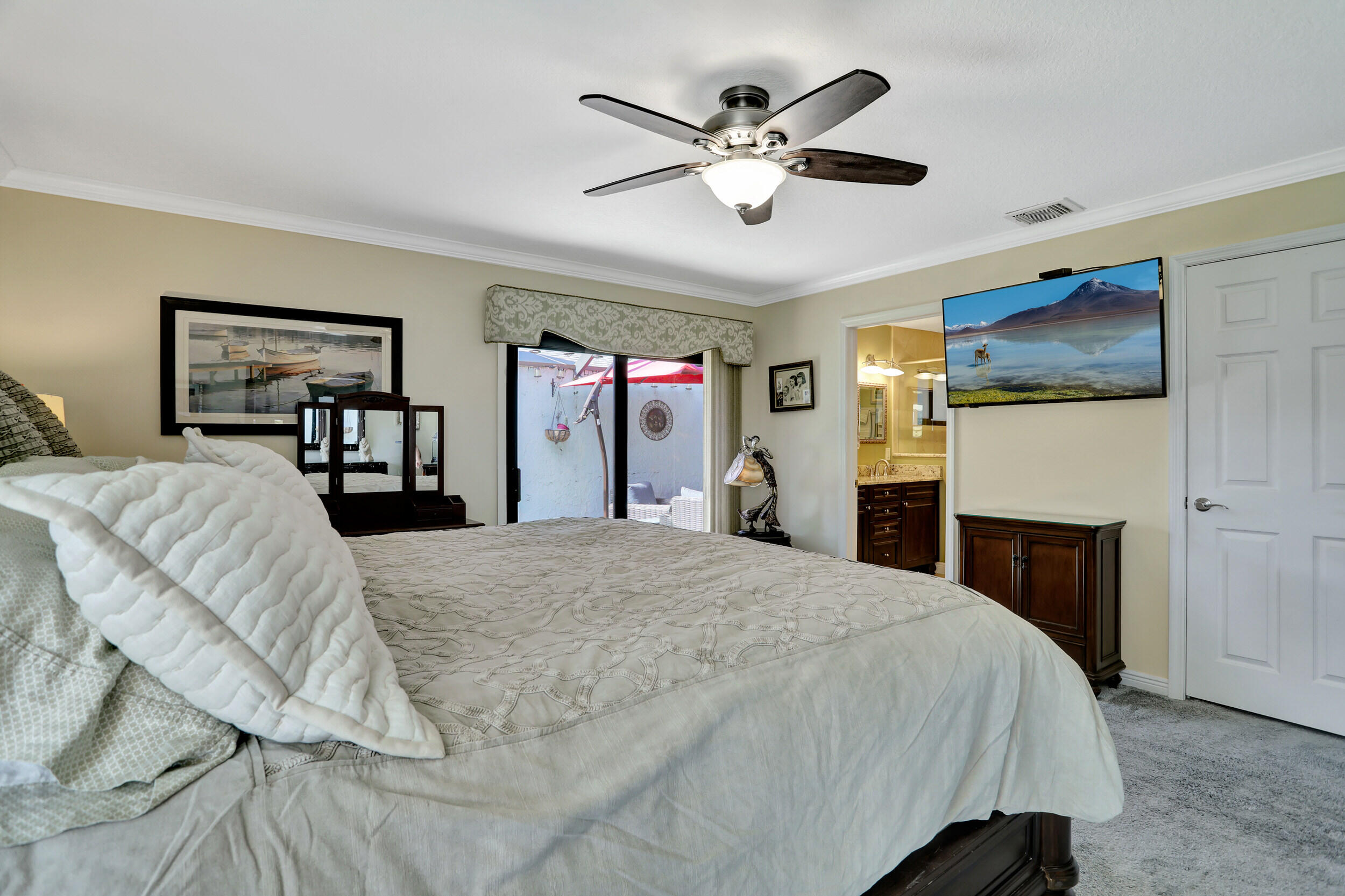 9142 Southwest 22nd Street, Unit E Boca Raton, FL 33428 - Photo 20 of 51 a spacious bedroom with a large bed and a ceiling fan