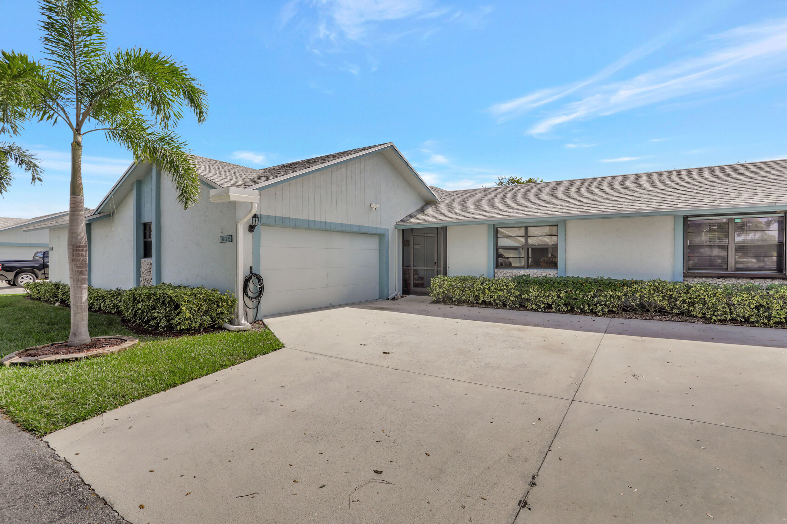 9142 Southwest 22nd Street, Unit E Boca Raton, FL 33428 - Photo 2 of 51 a front view of a house with a yard and garage