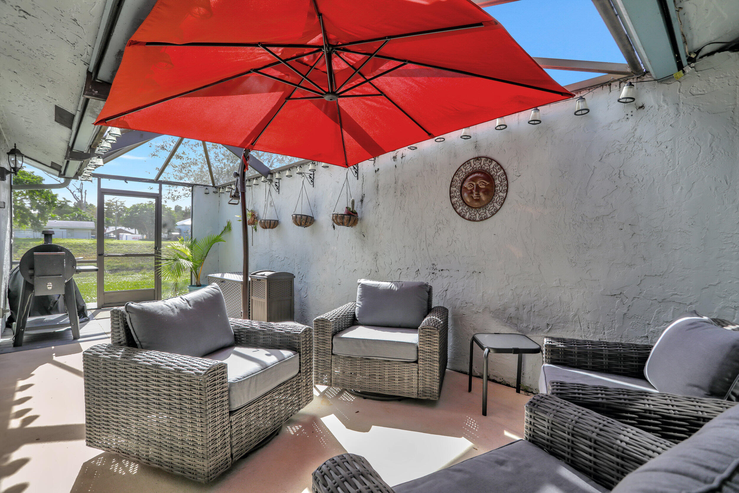 9142 Southwest 22nd Street, Unit E Boca Raton, FL 33428 - Photo 27 of 51 a view of an outdoor sitting area with furniture and umbrella