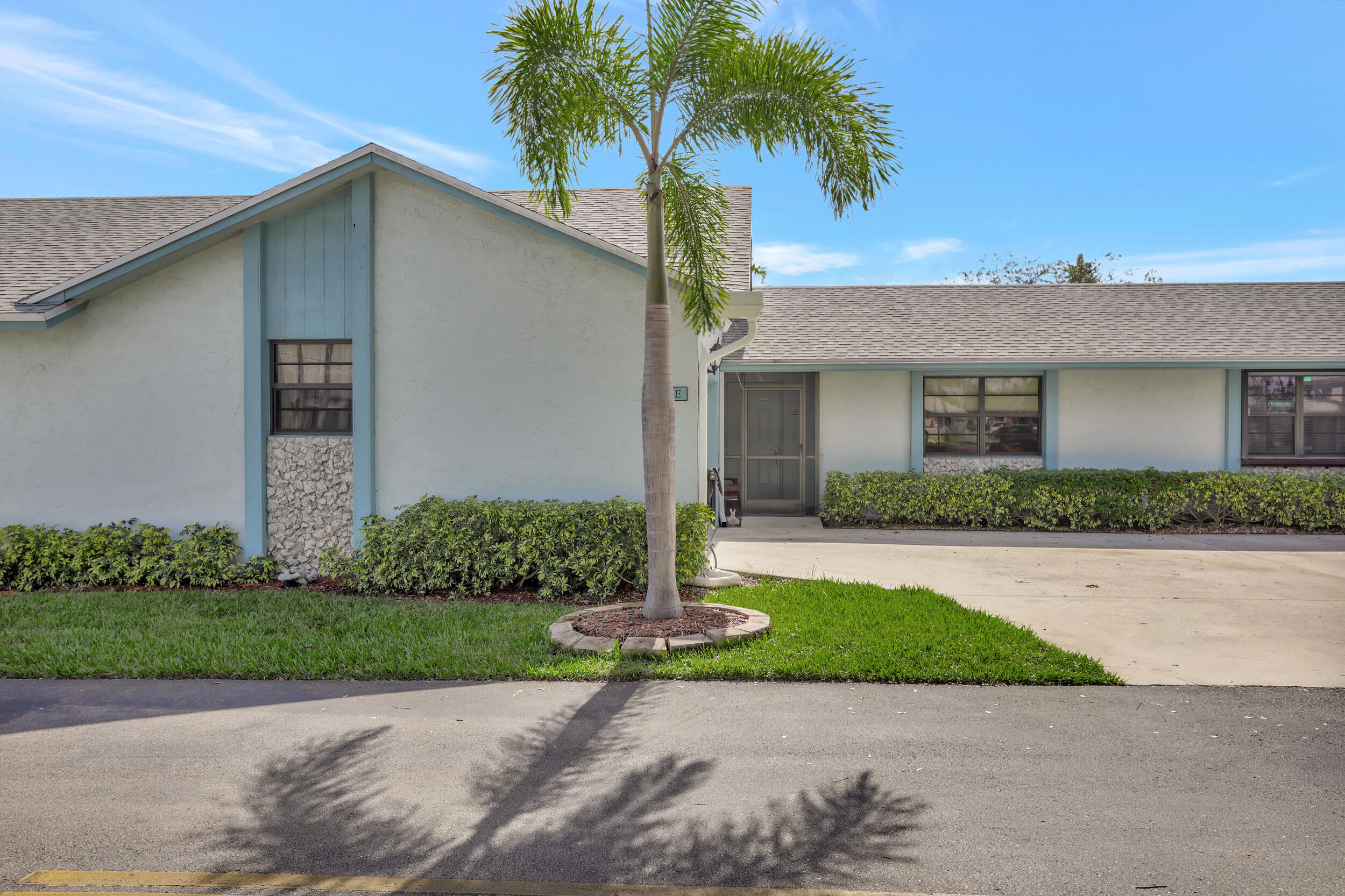9142 Southwest 22nd Street, Unit E Boca Raton, FL 33428 - Photo 47 of 51 a front view of a house with a yard and garage