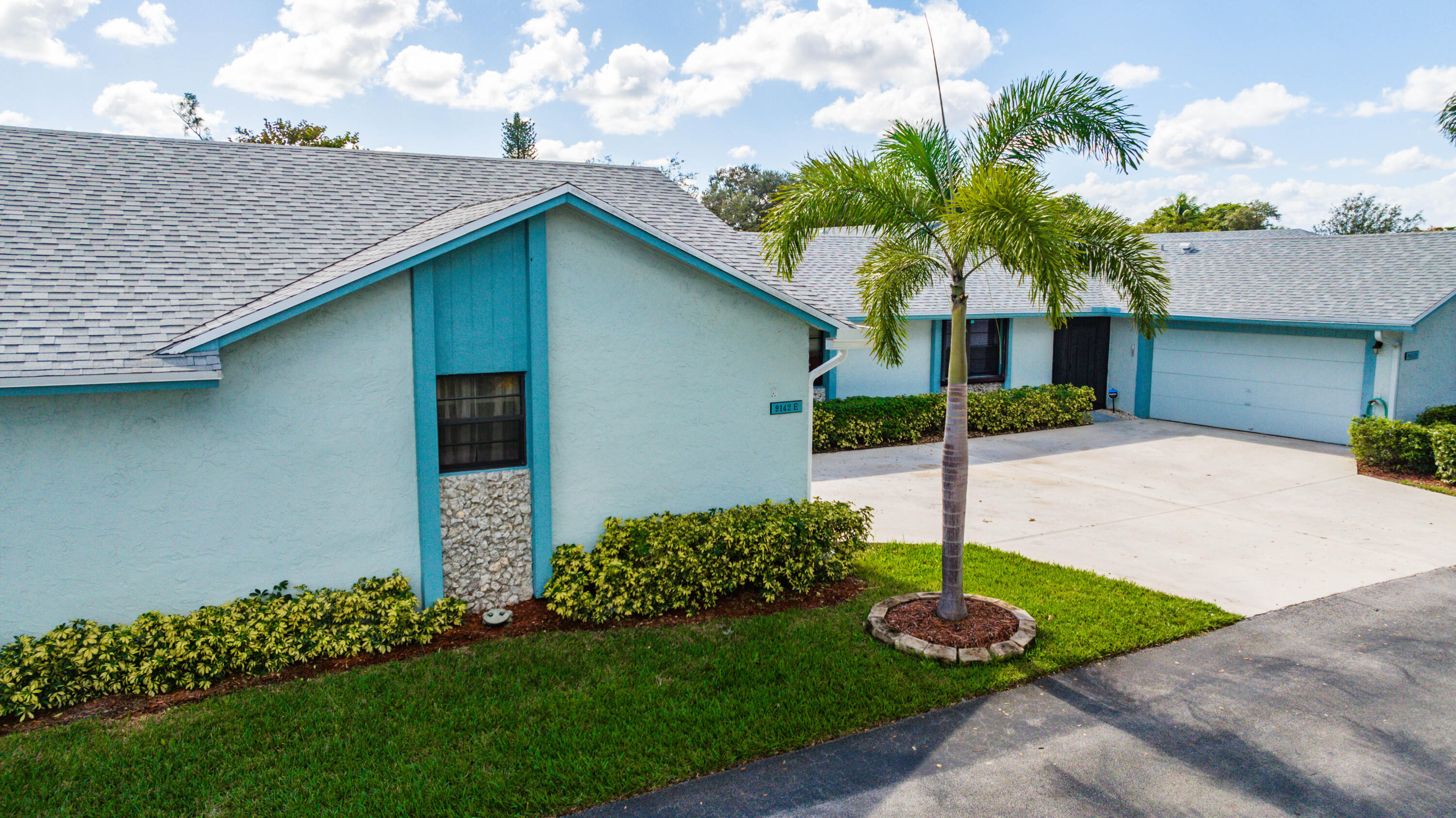9142 Southwest 22nd Street, Unit E Boca Raton, FL 33428 - Photo 48 of 51 a front view of a house with a garden and plants