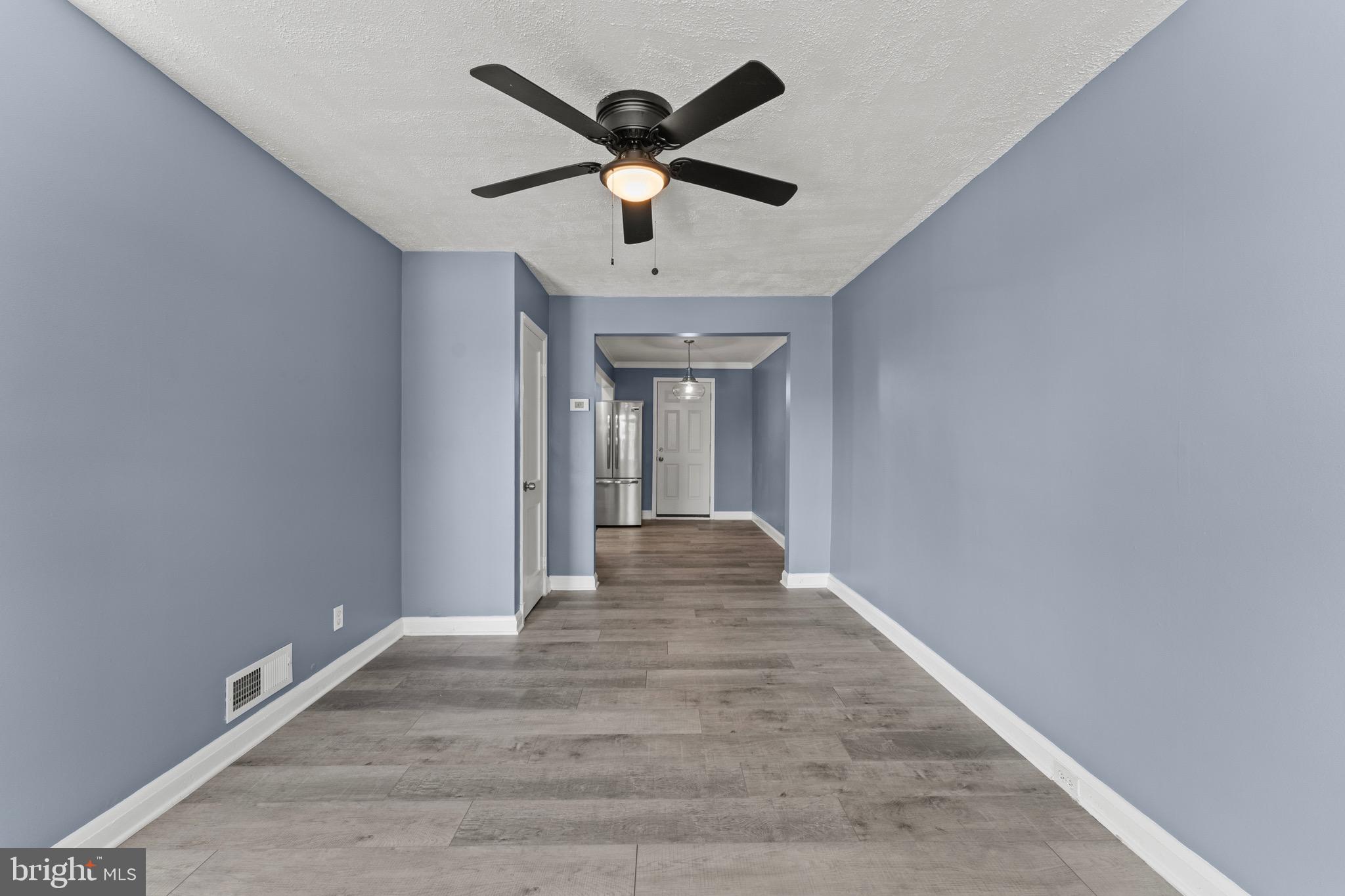 3693 Kenyon Avenue Baltimore, MD 21213 - Photo 3 of 34 a view of a livingroom with a ceiling fan and wooden floor