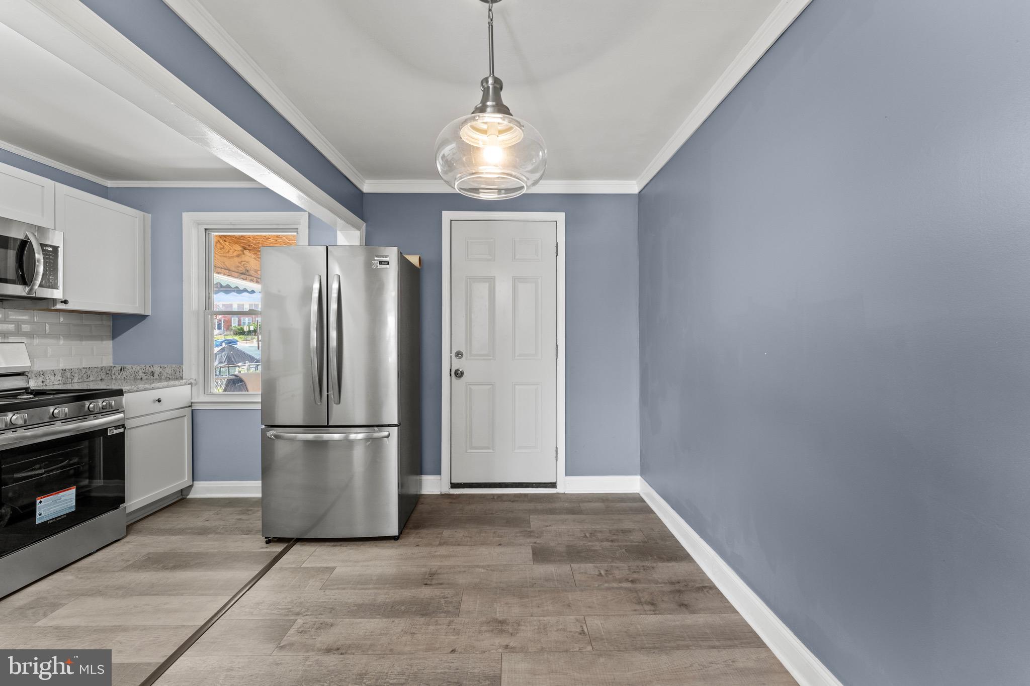 3693 Kenyon Avenue Baltimore, MD 21213 - Photo 6 of 34 a kitchen with stainless steel appliances granite countertop a refrigerator a stove a microwave and a refrigerator