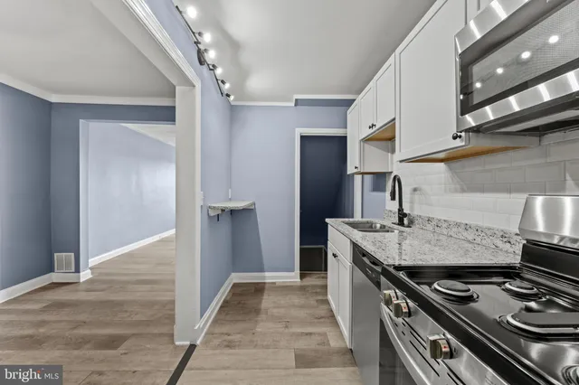 a kitchen with stainless steel appliances granite countertop a stove and a refrigerator