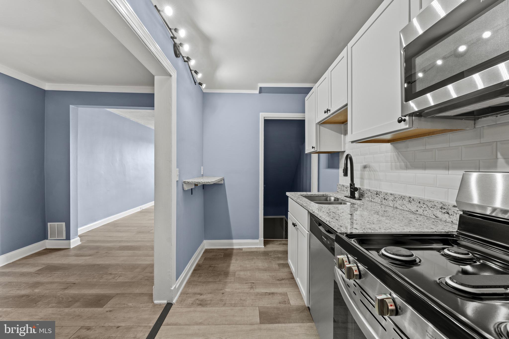 3693 Kenyon Avenue Baltimore, MD 21213 - Photo 8 of 34 a kitchen with stainless steel appliances granite countertop a stove and a refrigerator