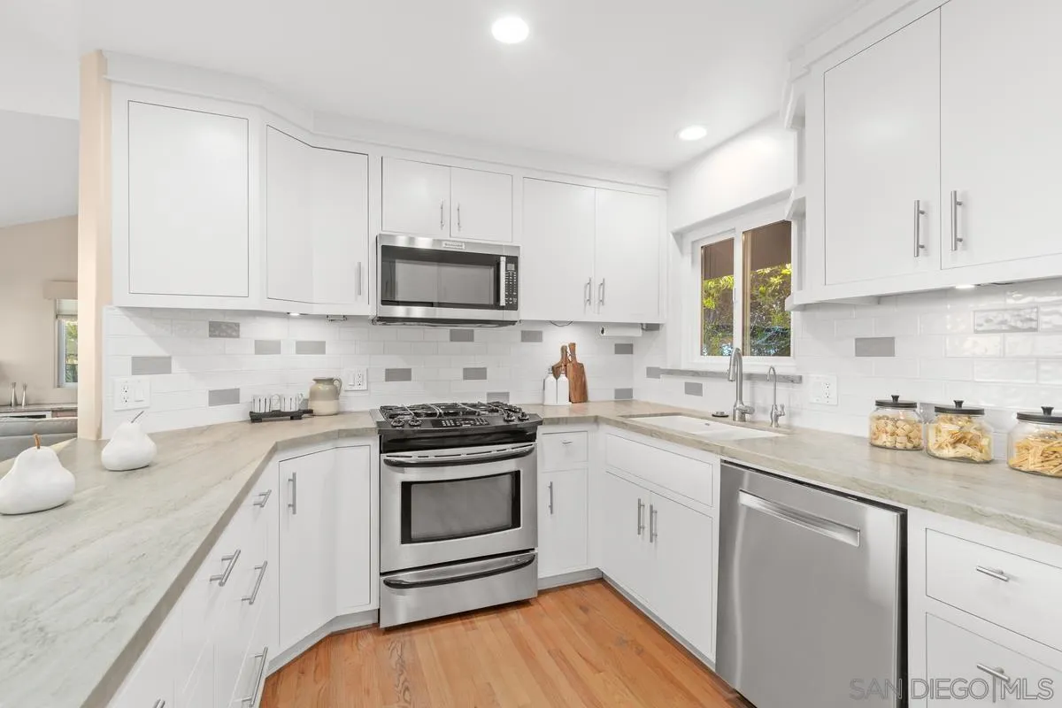 231 5th Street Encinitas, CA 92024 - Photo 20 of 43 a kitchen with stainless steel appliances a sink a stove a microwave a refrigerator and cabinets