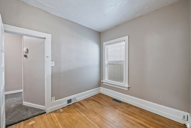 75 600 West Provo, UT 84601 - Photo 13 of 26 Room featuring hardwood flooring, white trim, a single window with blinds, and light-toned wall paint