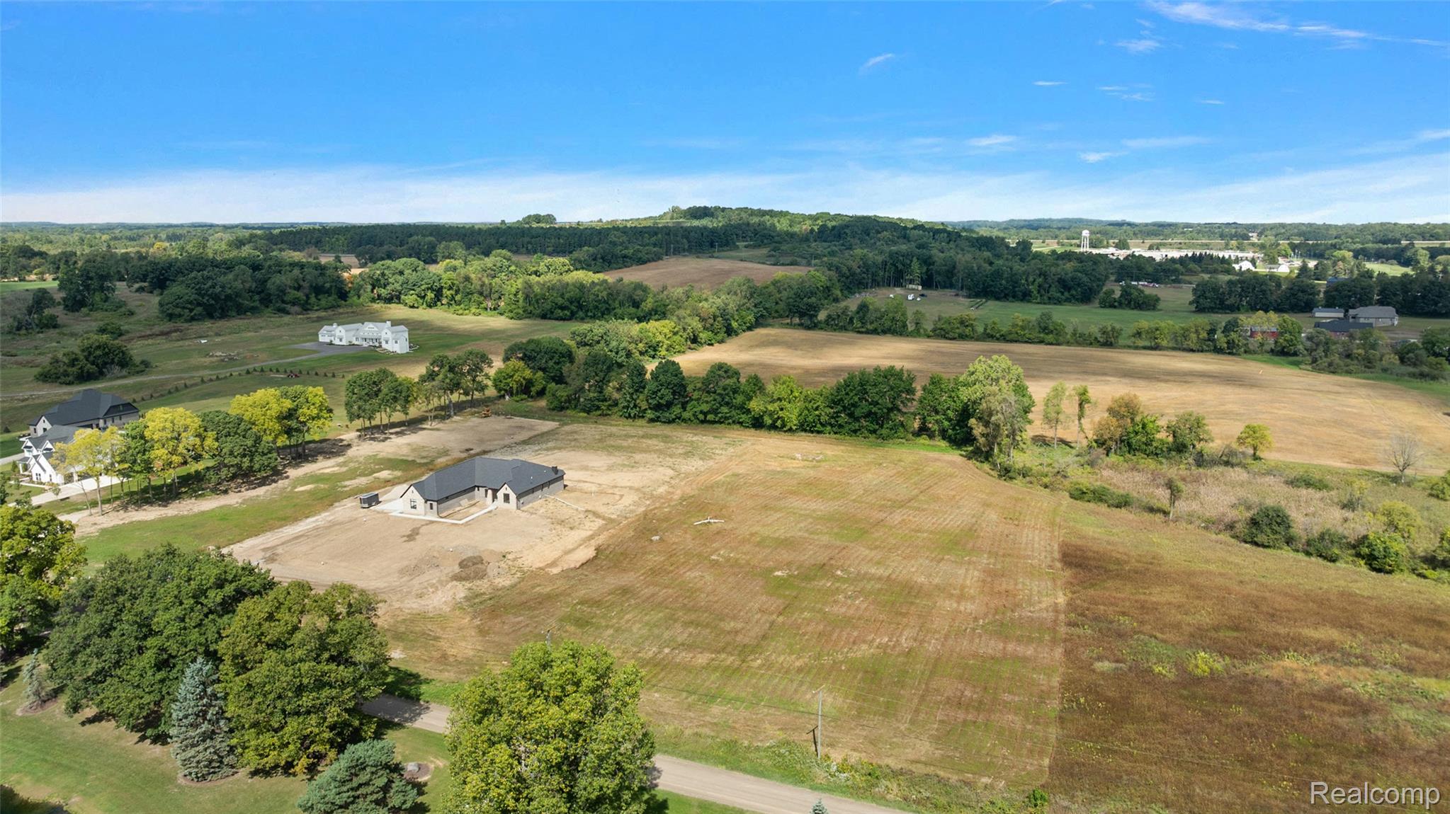 4059 Taft Road Romeo, MI 48065 - Photo 10 of 59 Newly constructed residence with a dark roof and light-toned exterior, positioned within expansive cleared land
