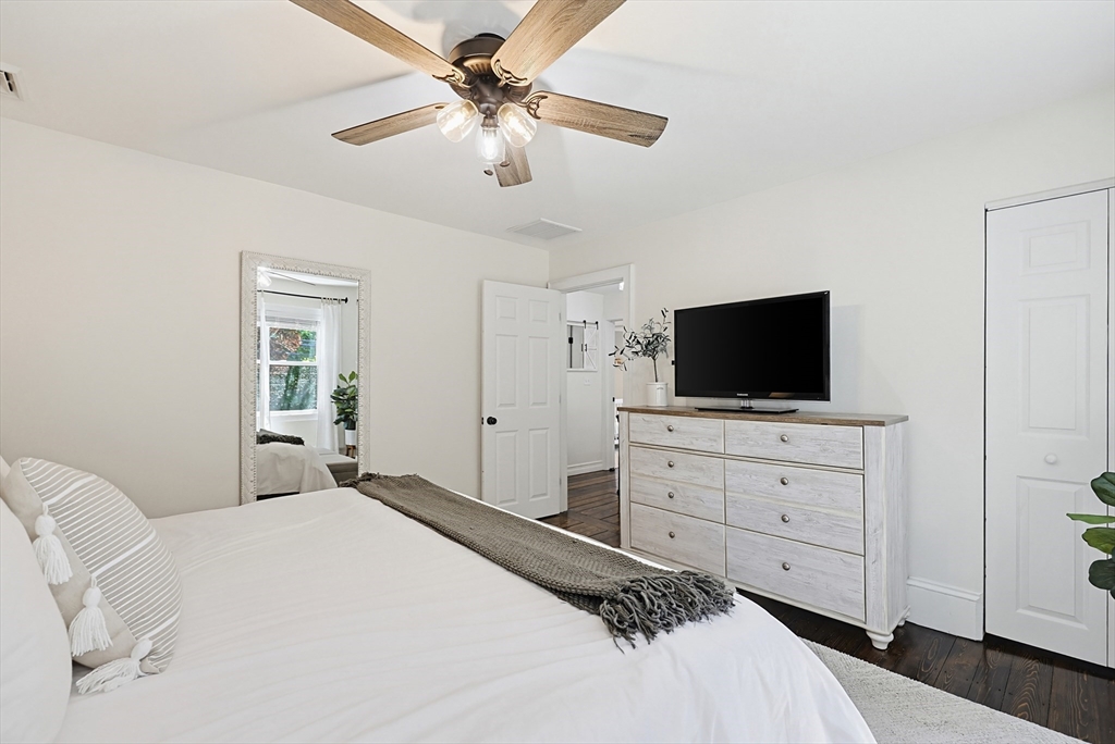 345 Sherman Street Canton, MA 02021 - Photo 21 of 42 a bedroom with a large bed and a flat tv screen on dresser