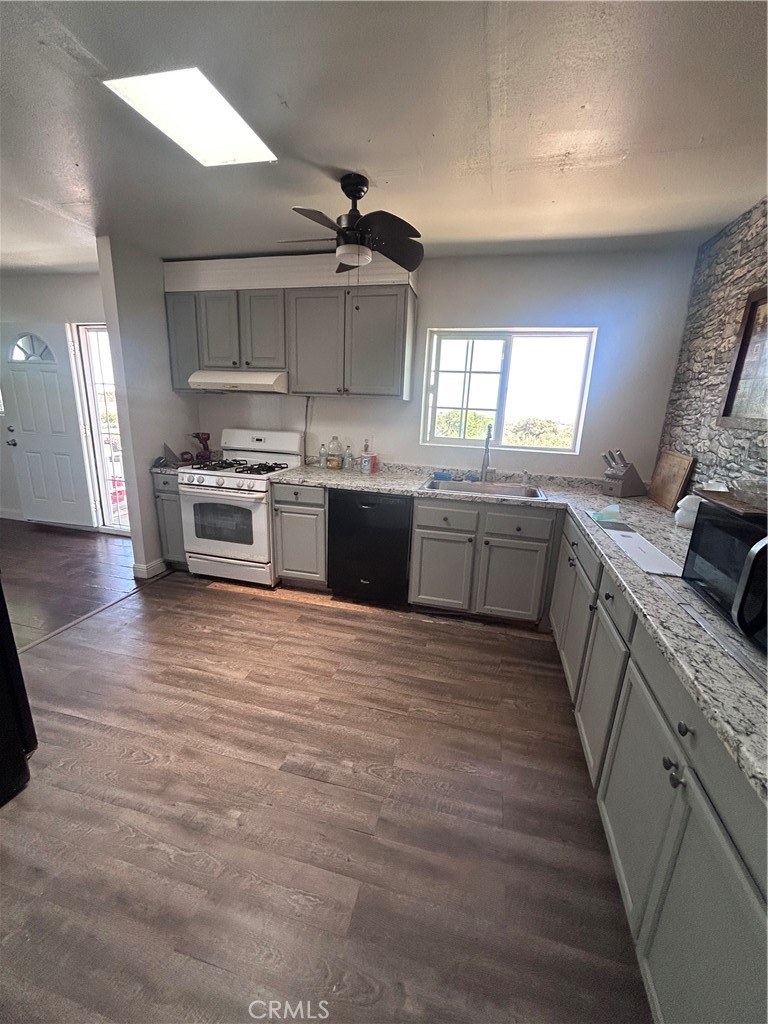 8471 Caughlin Road Phelan, CA 92371 - Photo 14 of 21 a large kitchen with stainless steel appliances granite countertop a stove and a wooden floors