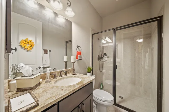 a bathroom with a granite countertop sink toilet and shower