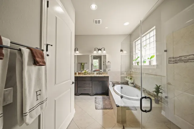 a spacious bathroom with a granite countertop sink and a mirror