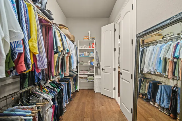 a view of walk in closet with clothes and shoes