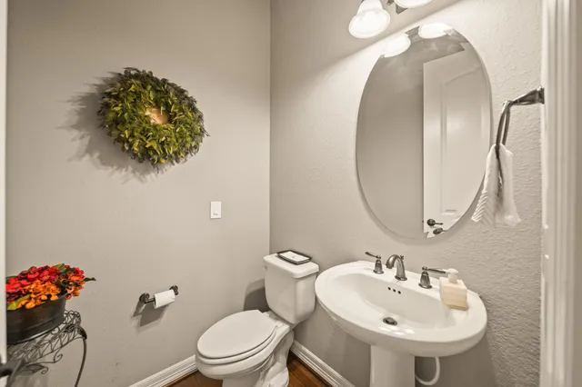 a bathroom with a sink mirror and toilet