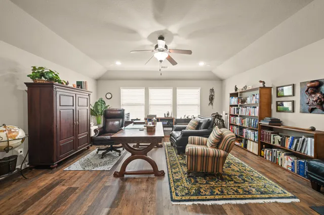 a living room with furniture a bookshelf and a book shelf