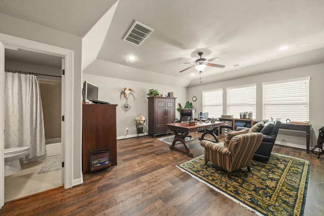 a living room with furniture ceiling fan and a rug