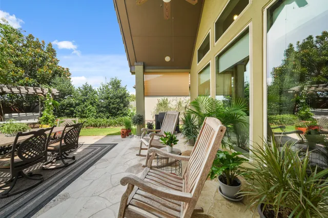 a view of a patio with table and chairs potted plants with wooden floor and fence