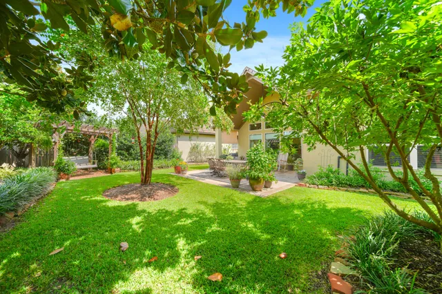 a view of a backyard with table and chairs and a large tree