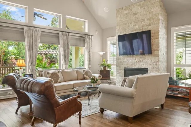 a living room with furniture a large window and a fireplace