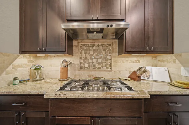 a kitchen with granite countertop a stove and cabinets
