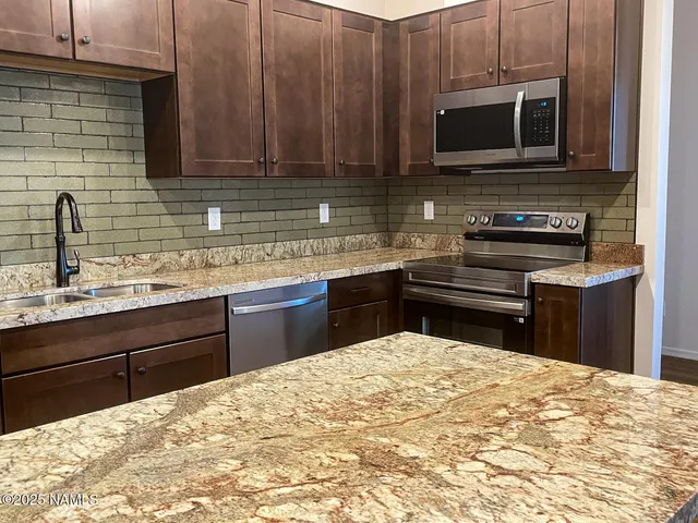 a kitchen with stainless steel appliances granite countertop a sink counter space and cabinets