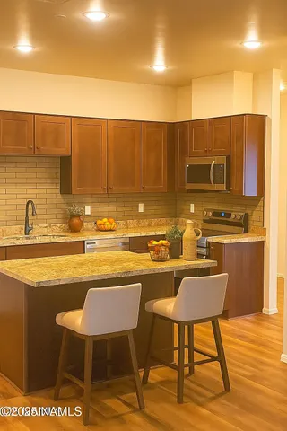 a kitchen with stainless steel appliances a refrigerator and a stove top oven