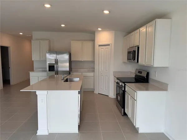 a kitchen with a sink a stove top oven a counter space and cabinets