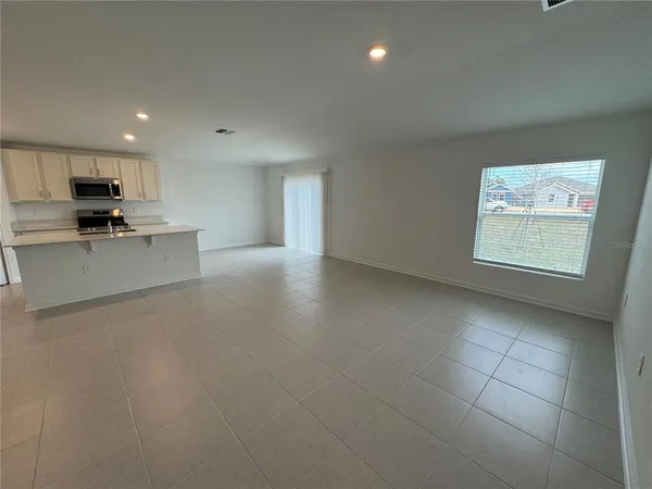 a view of a kitchen with a sink wooden cabinets and glass door
