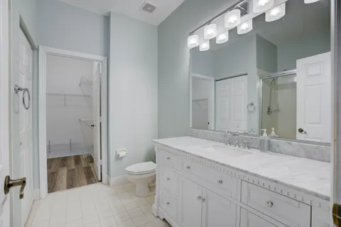 a spacious bathroom with a granite countertop sink a toilet and a shower