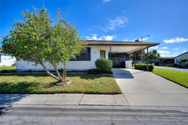 a front view of a house with a yard and potted plants