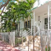 a view of a house with a large tree and wooden fence
