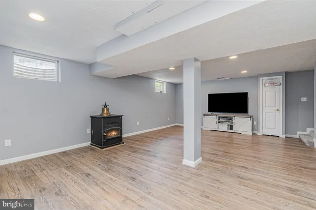 a view of empty room with wooden floor and windows