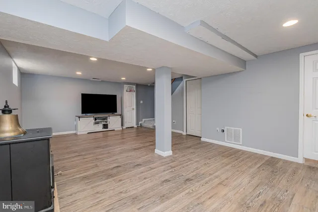 a view of a livingroom with wooden floor and a flat screen tv
