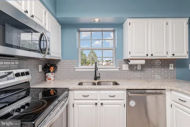 a kitchen with stainless steel appliances granite countertop a sink stove and cabinets