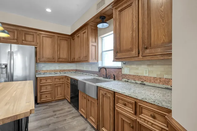 a kitchen with stainless steel appliances granite countertop a stove and a wooden cabinets